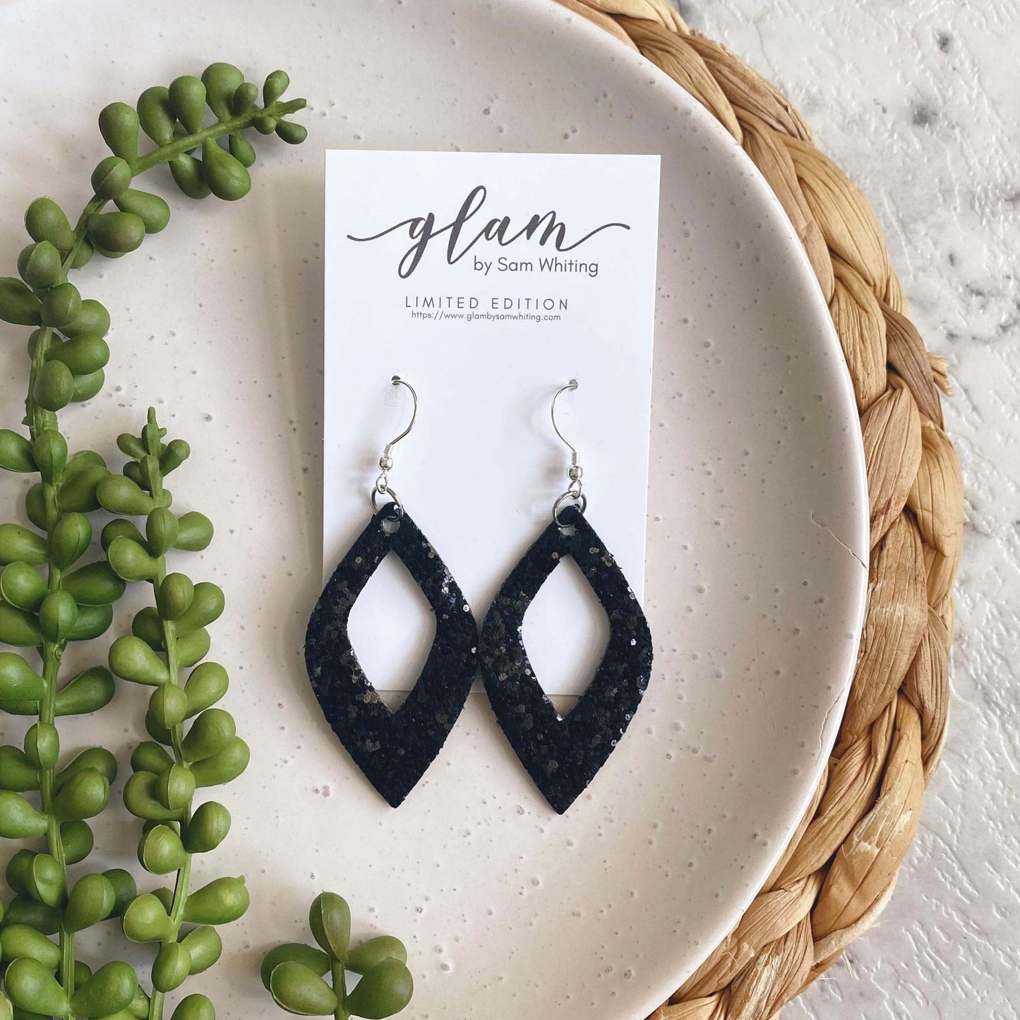 Black sparkle diamond cut out leather earrings with a silver coloured hook.