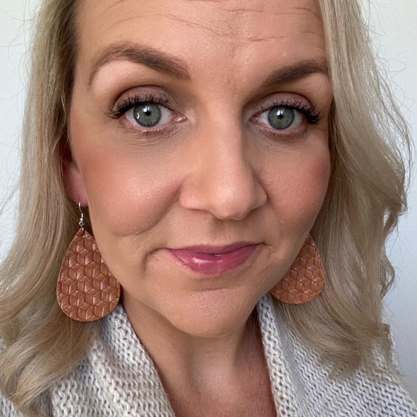 Textured tan teardrops. Leather earrings with silver coloured hook.