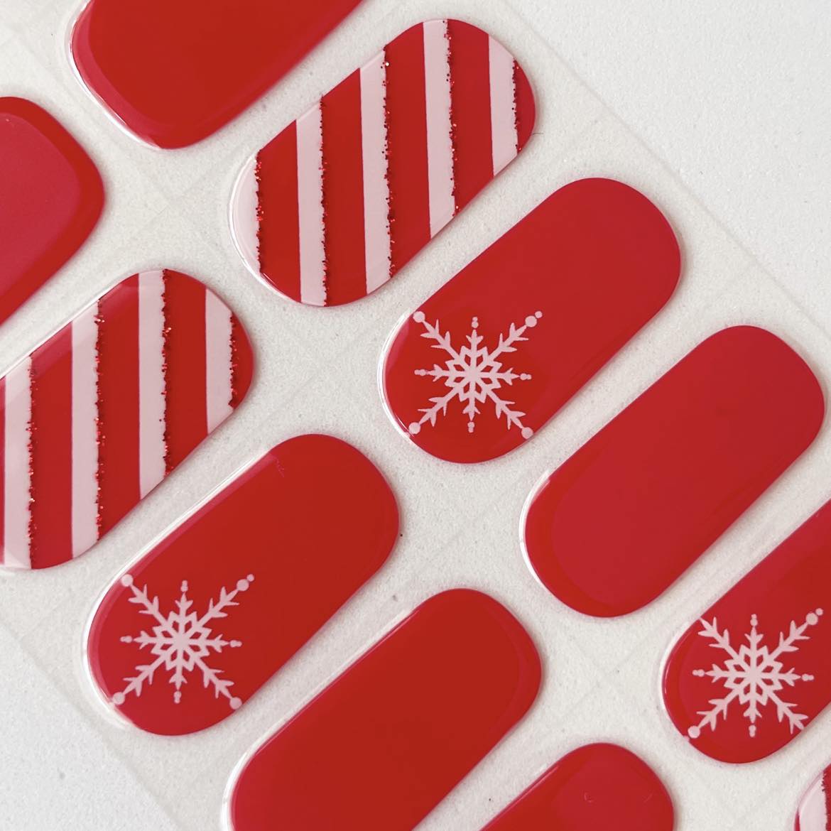 Red nail art stickers with snowflake designs on a white background
