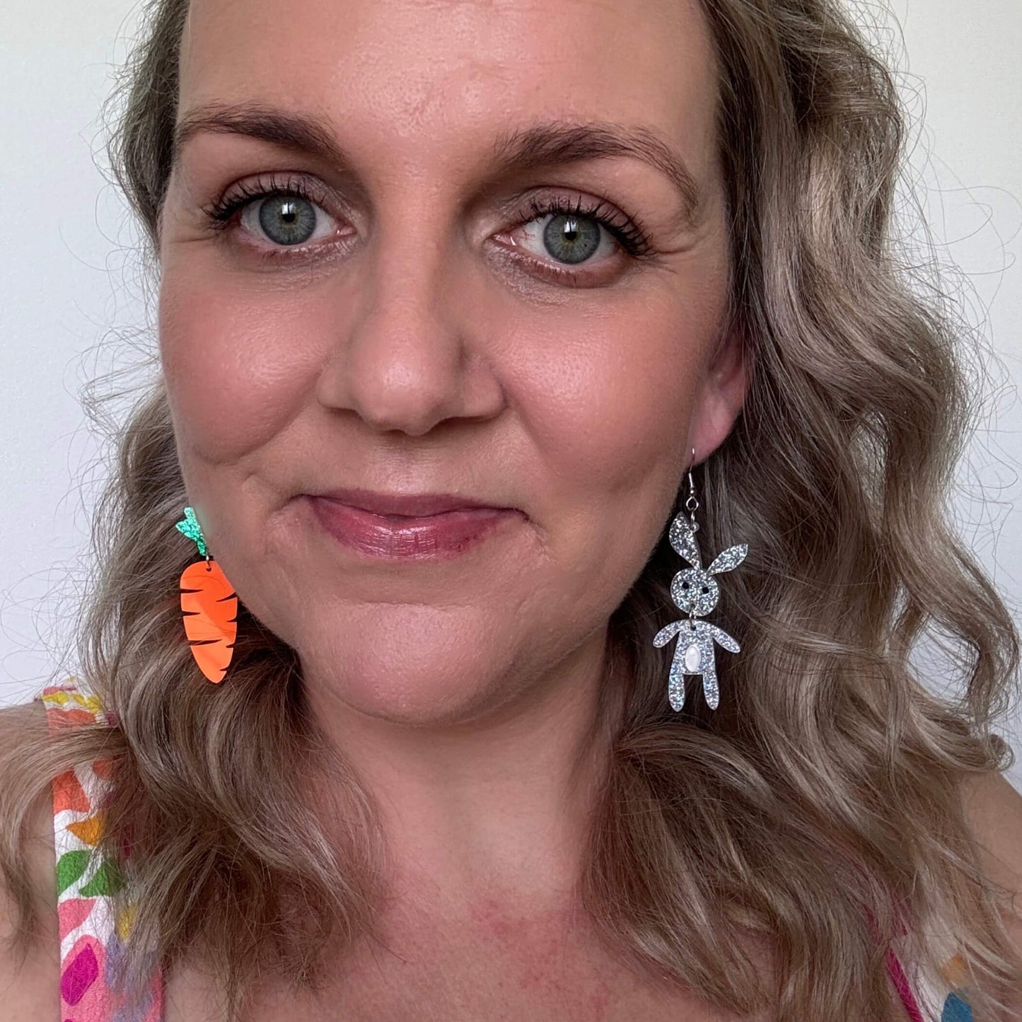 selfie of mismatched acrylic easter carrot and bunny earrings