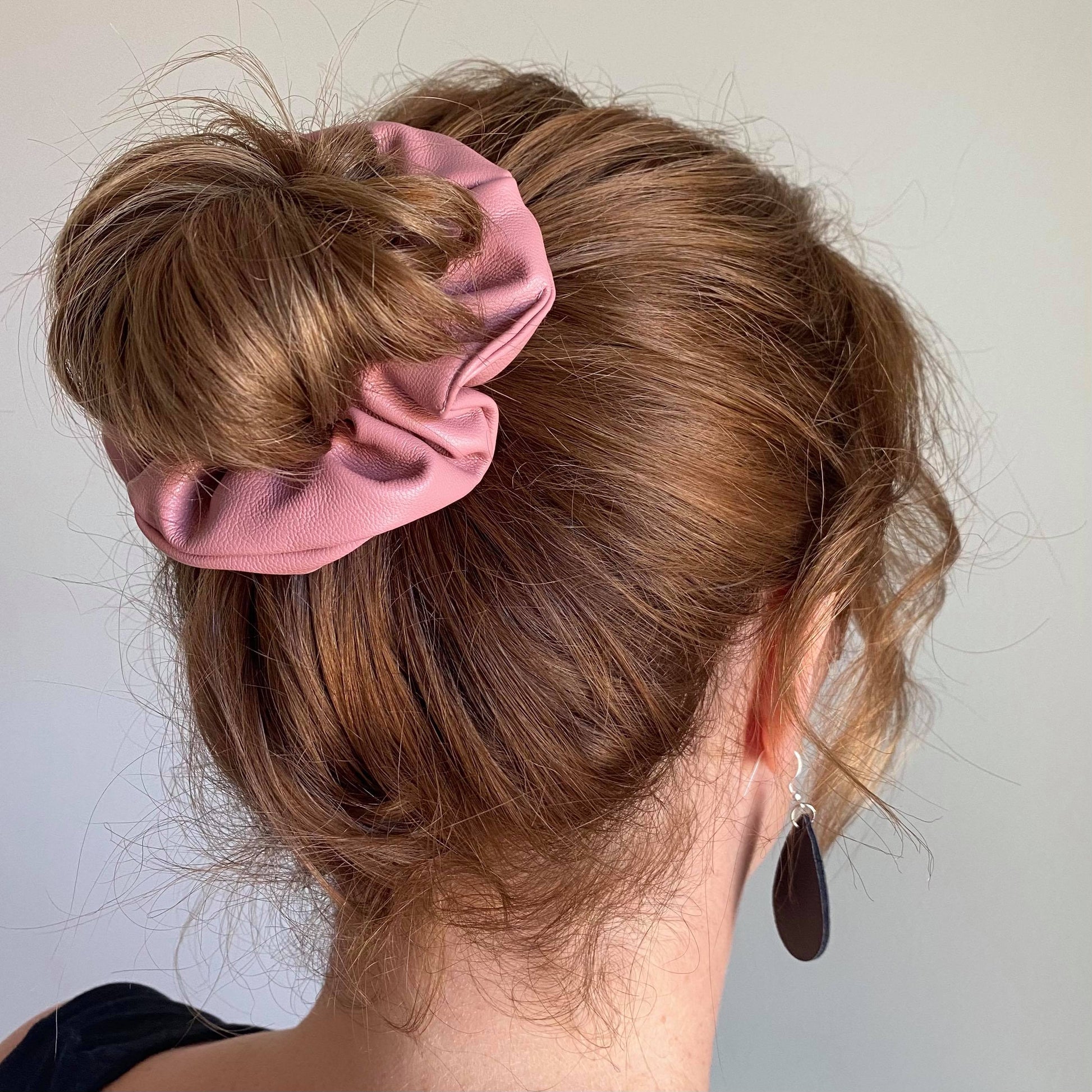 Dusty pink faux leather hair scrunchie around bun
