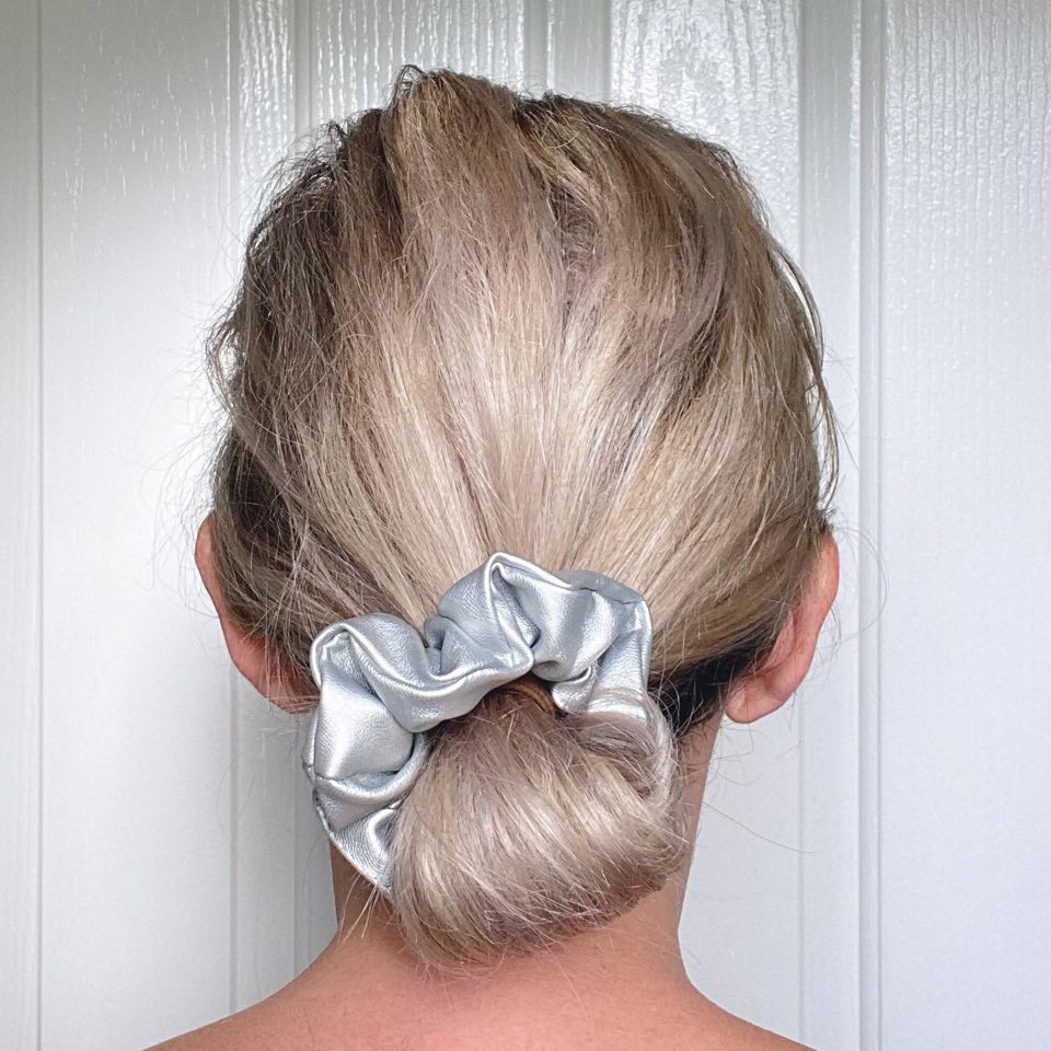 Silver faux leather hair scrunchie in a low bun