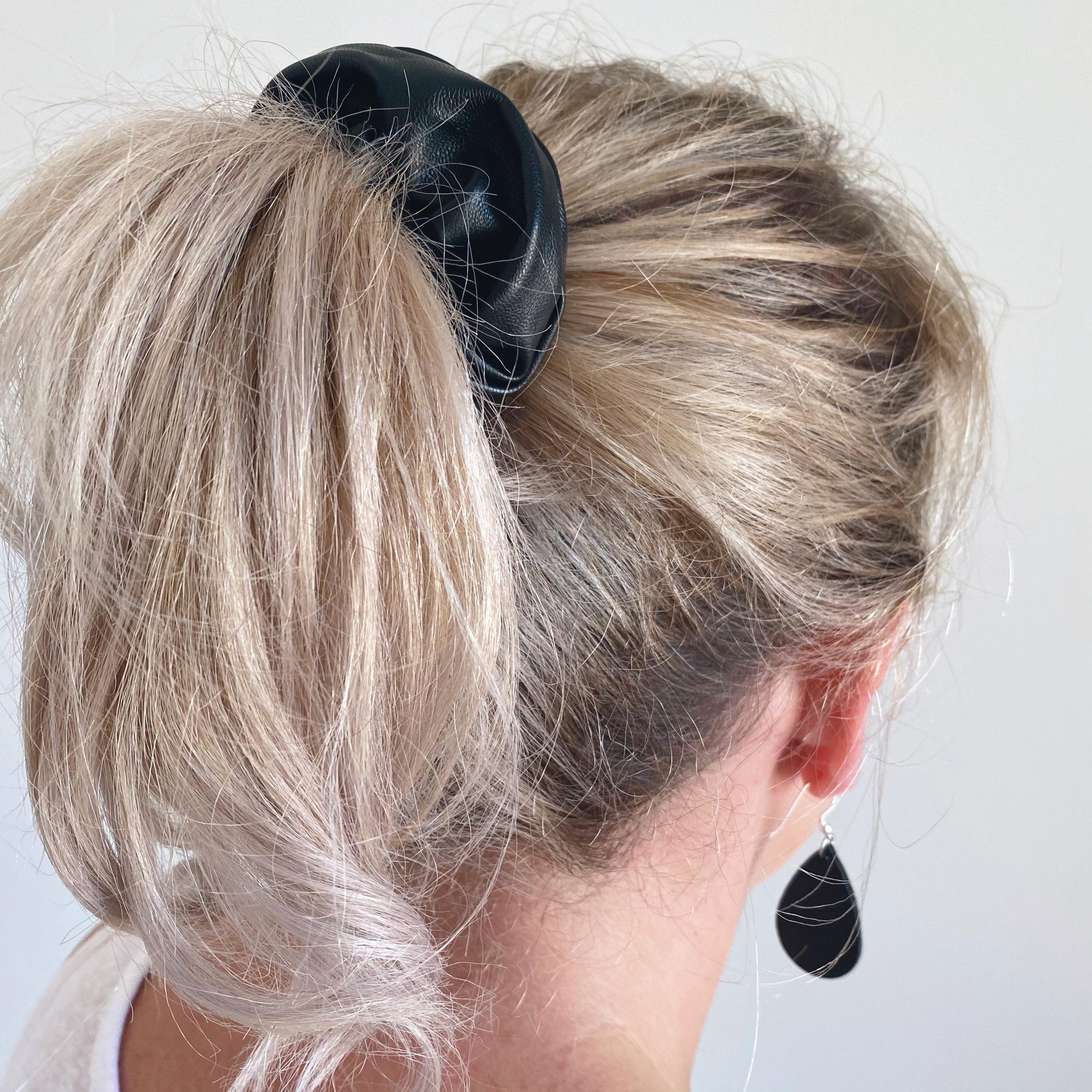 Black faux leather hair scrunchie in ponytail