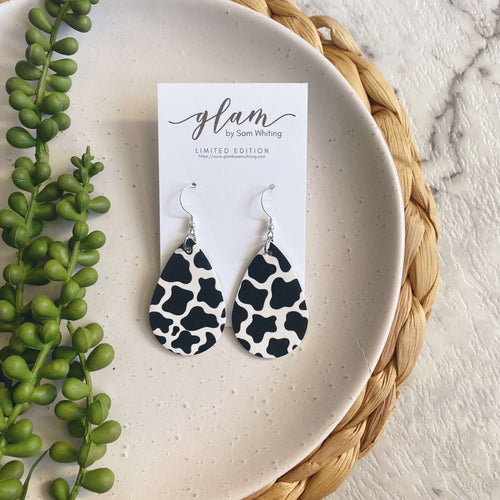 Cow print mini leather earrings on a silver coloured hook.  