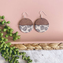 Load image into Gallery viewer, Frond and timber semi circles on a silver coloured hook. 
