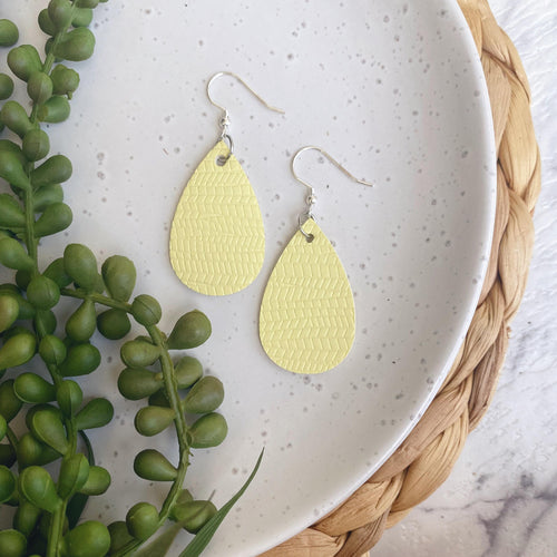 Sunshine yellow embossed mini leather earrings with a silver coloured hook. 