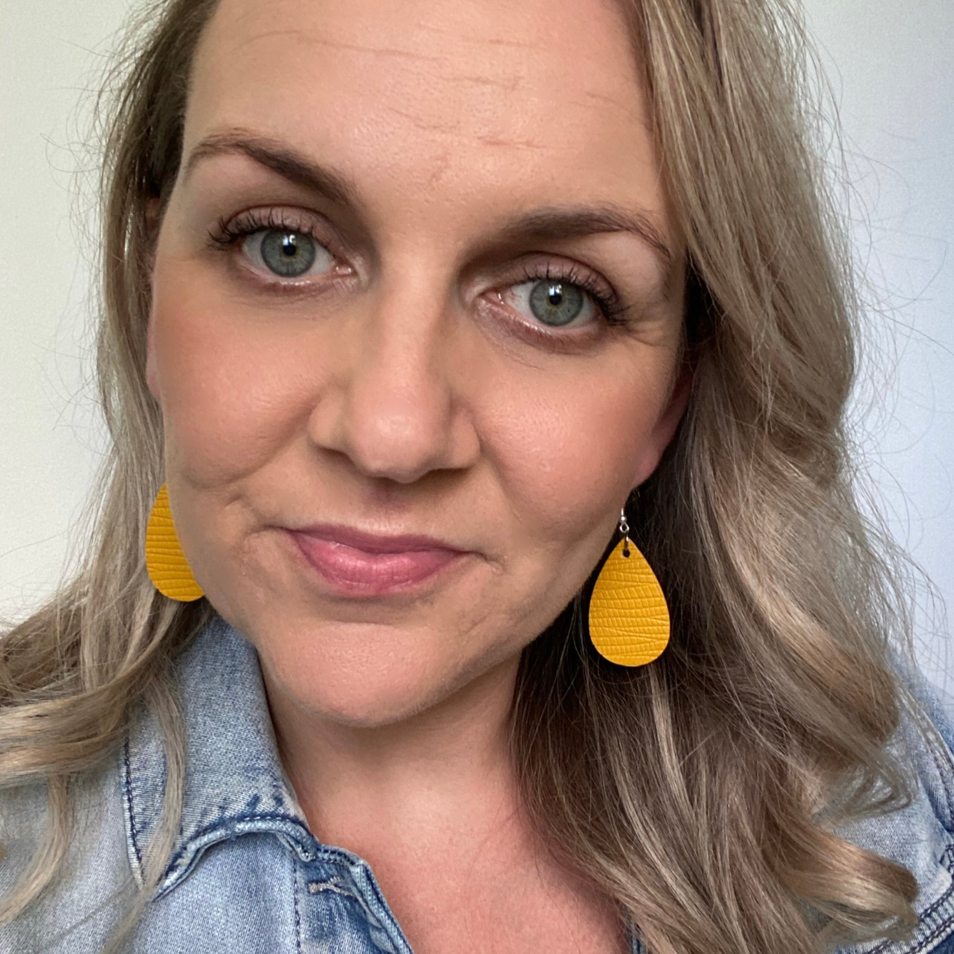 Mustard embossed mini leather earrings on a silver coloured hook. 