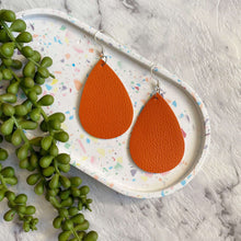 Load image into Gallery viewer, Orange Teardrop leather earrings on a silver coloured hook. 
