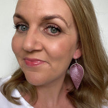 Load image into Gallery viewer, Pink Metallic faux leather petal earrings selfie with silver hook.

