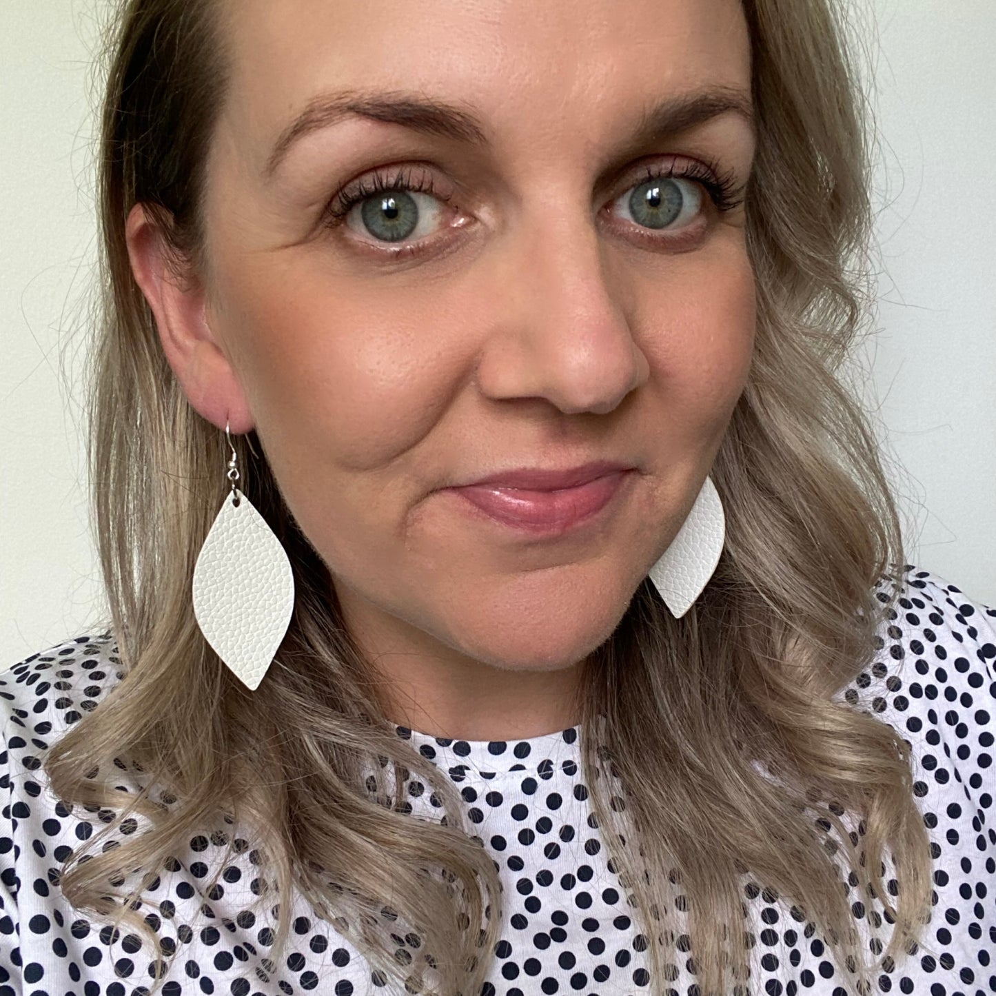 White leaf leather earrings on a silver coloured hook. 